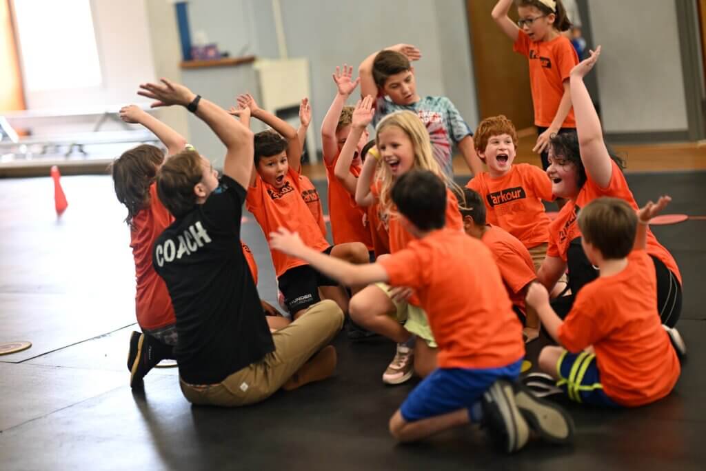 Children cheering with their arms in the air after class