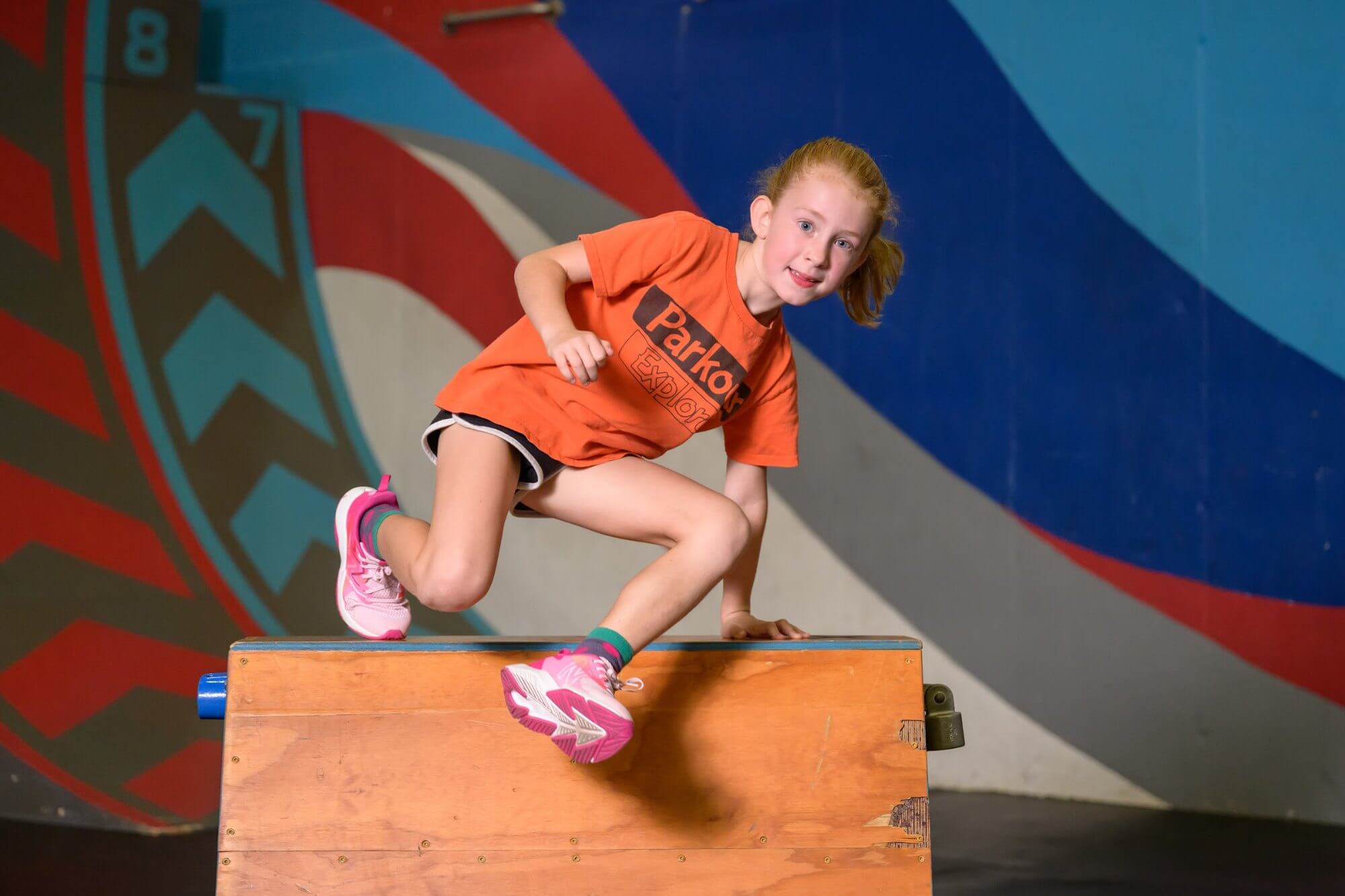 Student vaulting over a box at parkour class