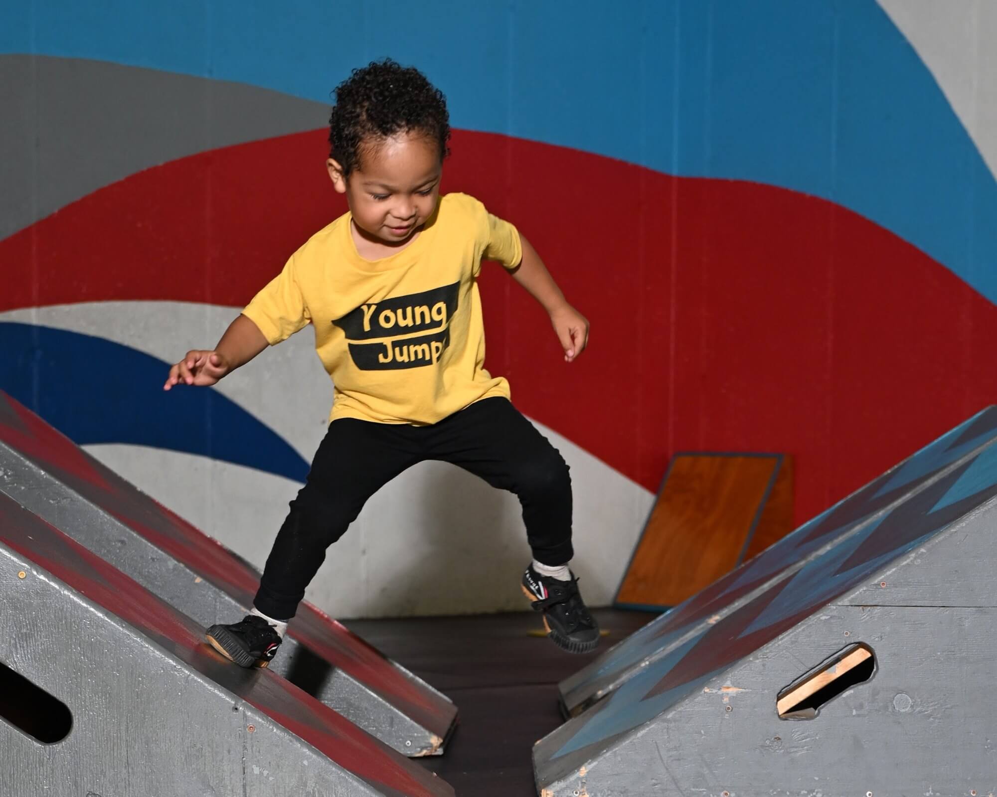 Young Jumps 3M4 8116 Young child balancing with arms out on a low ramp
